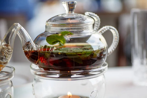 Tea menta levelek egy üveg teáskanna egy gyertyát. — Stock Fotó