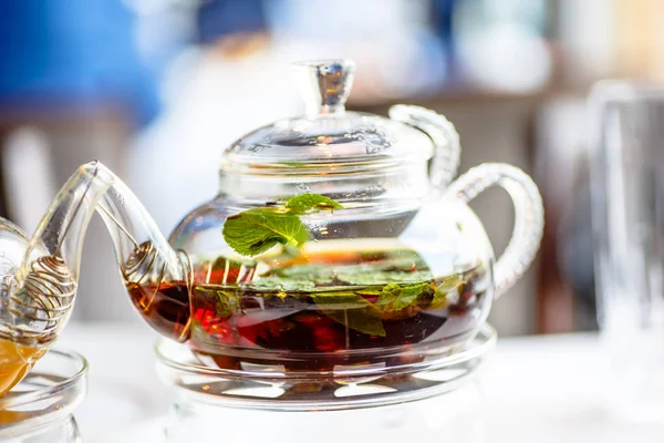 Tee mit Minzblättern in einer Glasteekanne mit Kerze. — Stockfoto