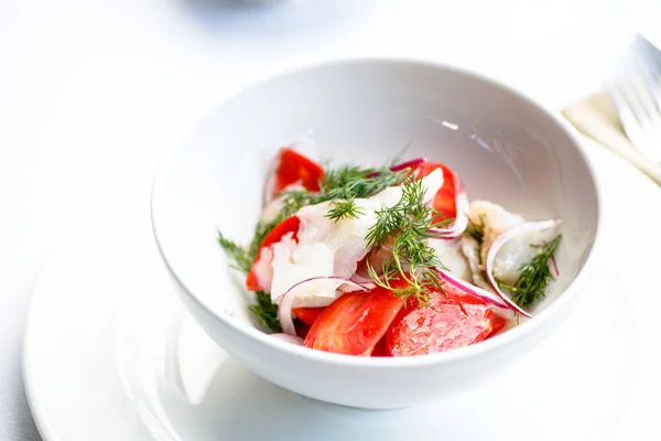 Salat aus Tomaten, Zwiebeln und geräuchertem Heilbutt. — Stockfoto