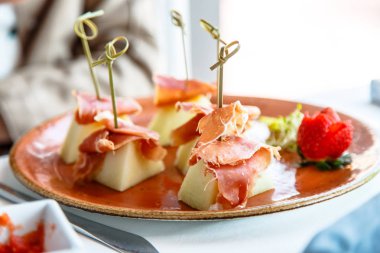 Kavun Serrano jambonu ile plaka üzerinde yatıyordu.