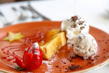 Peynirli kek ve dondurma hayalar plaka üzerinde.