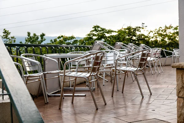 Metal  Aluminum desks and tables in a cafe after rain. Deserted. — Stock Photo, Image