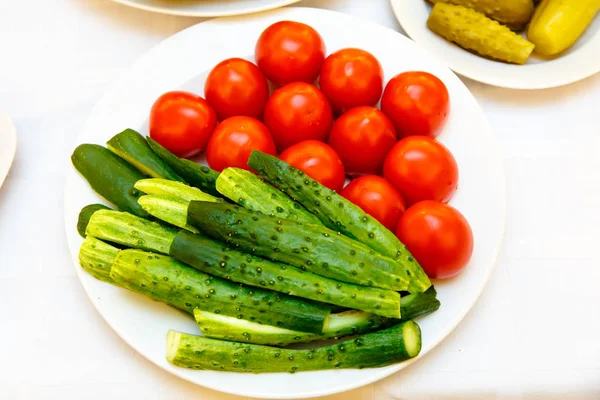 Pepinos frescos y tomates en el plato . — Foto de Stock