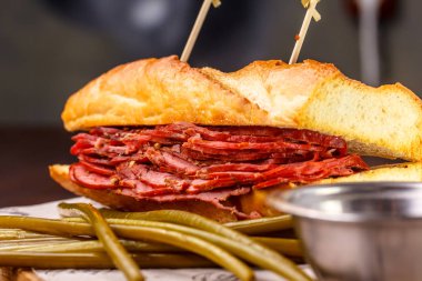 Sandviç pastırma kağıt üzerine bir tahta üzerinde yatıyor