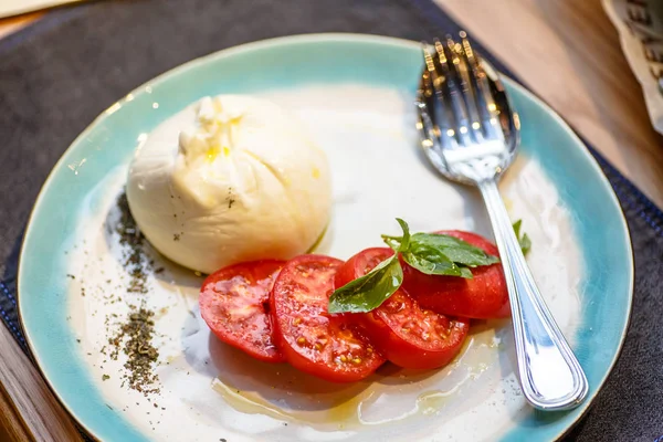 The tomato slices and burrata cheese are on the plate. version o — Stock Photo, Image