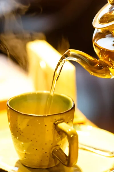 Varmt te hälls i koppen från glas tekannan — Stockfoto