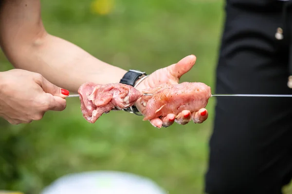 La chica pone trozos de carne para un shish kebab en un pincho, púas — Foto de Stock