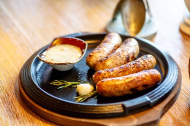 Üzerinde siyah bir kızartma tavası hardallı sosis ızgara.