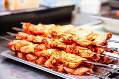 Tavuk parçaları şiş kebap pişirmek için bir şiş koymak.