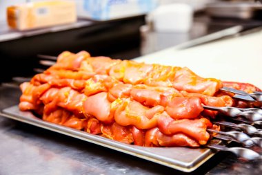 Tavuk parçaları şiş kebap pişirmek için bir şiş koymak.