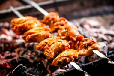 Izgarada kızartılmış tavuk parçaları (kanat ve uyluk).