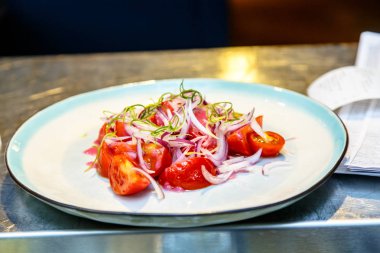 Salata Domates ve soğan plaka üzerinde yalan.