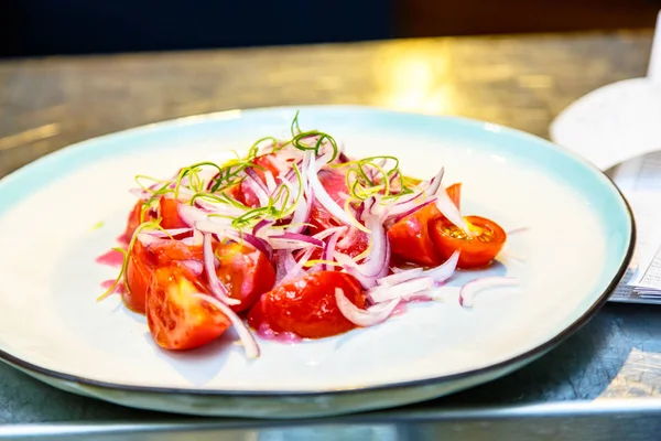 Salata Domates ve soğan plaka üzerinde yalan.