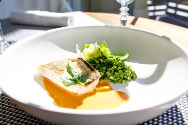 Izgara balık COD beyaz bir plaka üzerinde yatıyor.