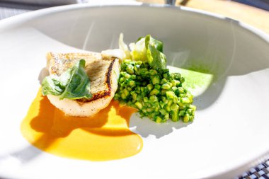 Izgara balık COD beyaz bir plaka üzerinde yatıyor.