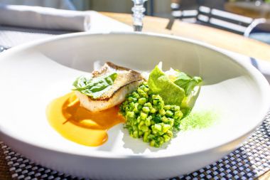 Izgara balık COD beyaz bir plaka üzerinde yatıyor.