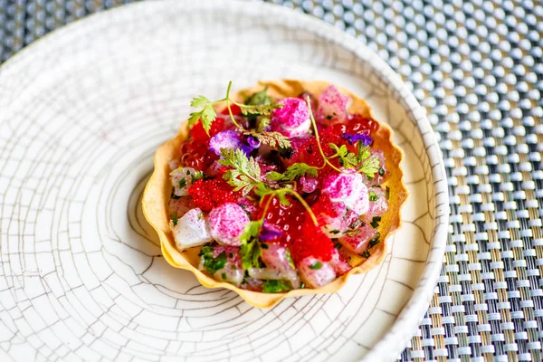 Appetizer of fish, caviar and flowers is in slice