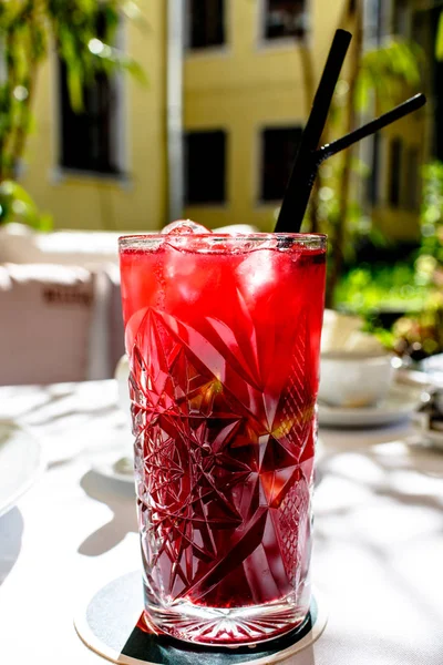 La limonada roja en el vaso está sobre la mesa en el jardín, Sunny . — Foto de Stock