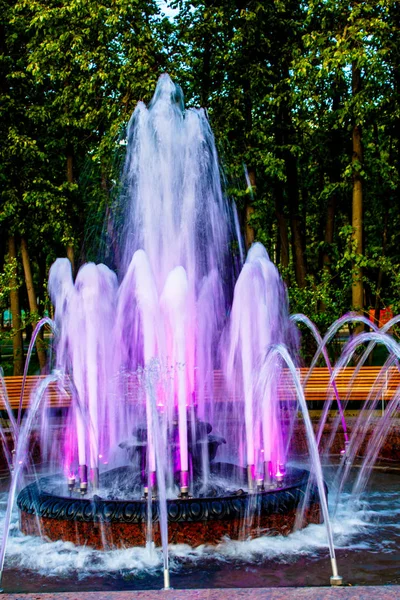 Leuchtende farbige Fontäne im Stadtpark, am Sommerabend. — Stockfoto