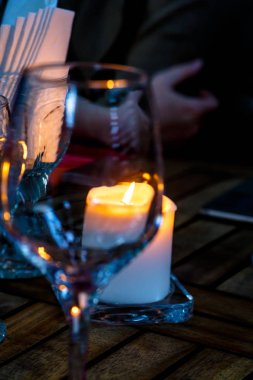 Şarap, gözlük ve yanan bir muma akşam masada. 