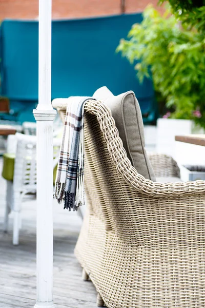 Plaid lies on the wicker furniture from rattan. Summer. — Stock Photo, Image