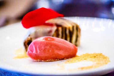 Çilek sorbe ve bir rulo sünger kek plaka üzerinde yatıyordu.