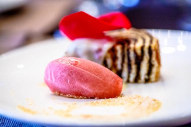 Çilek sorbe ve bir rulo sünger kek plaka üzerinde yatıyordu.