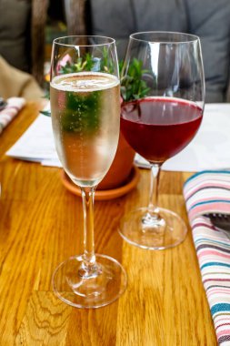 Bir bardak şampanya ve kırmızı şarap masada vardır.