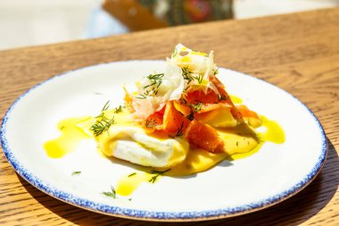 Tuzlanmış somon ile haşlanmış bir yumurta Benedict. Güneşli sabah, ara