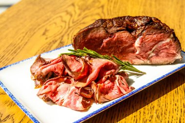 İnce dilimlenmiş biftek ve bir büyük dilim.