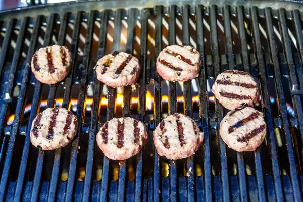 The little patties are fried on the grill the gas grill. — Stock Photo, Image