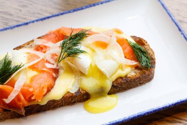 Güzel sandviç somon ve haşlanmış yumurta, yumurta sarısı ile akar