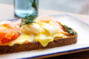 Güzel sandviç somon ve haşlanmış yumurta, yumurta sarısı ile akar