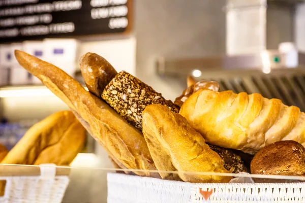 Pain fait maison et une baguette se trouve dans le panier sur le comptoir — Photo