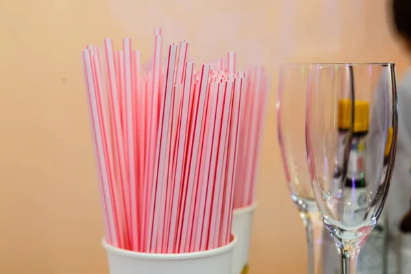 A lot of cocktail straws are in the glass.