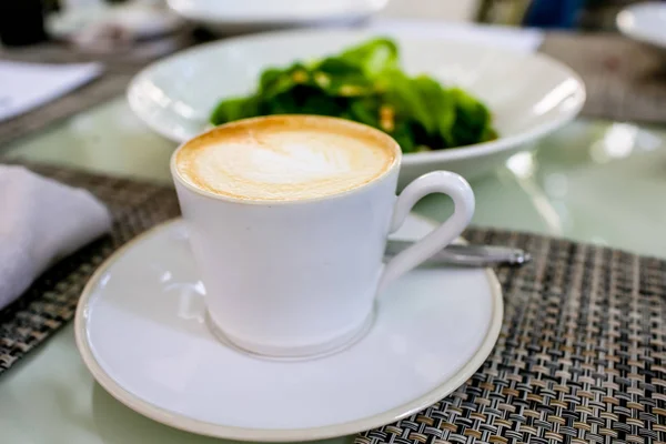 A cappuccino csésze van az asztalon — Stock Fotó