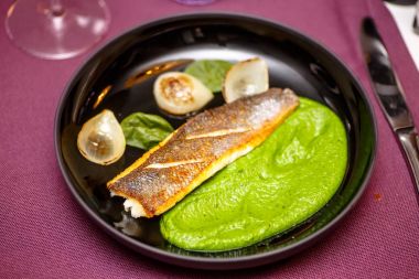 Kızarmış balık püresi yeşil bezelye ile plaka üzerinde yatıyor