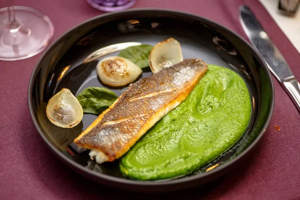 Kızarmış balık püresi yeşil bezelye ile plaka üzerinde yatıyor