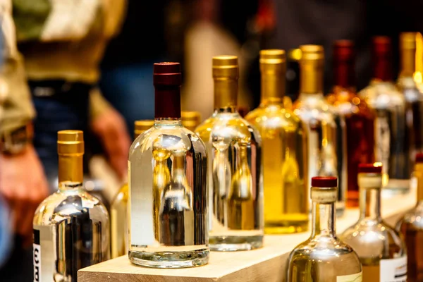 Um monte de garrafas diferentes de álcool forte ficar em uma fileira em t — Fotografia de Stock
