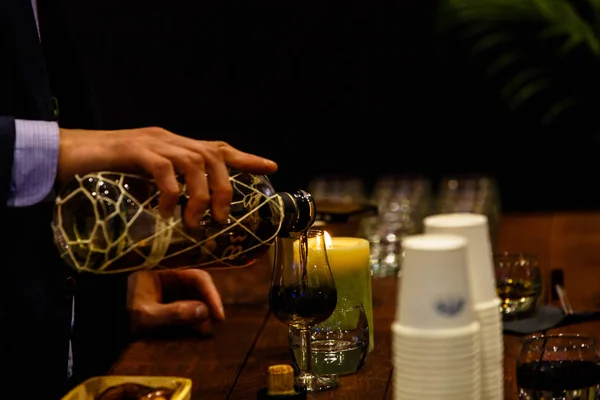 Barman nalévá do sklenice likér a ohřívá v t — Stock fotografie