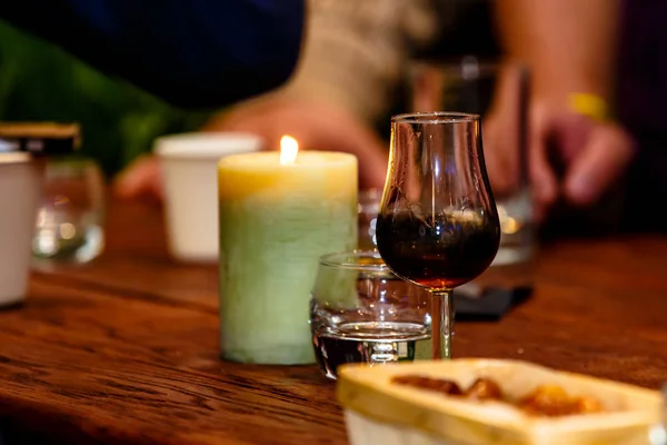 The bartender pours the liqueur into the glass and heats it in t