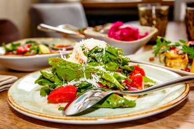 Salata marul ve domates, tepesinde th rendelenmiş peynir ile