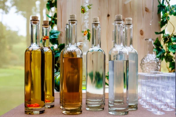 Genomskinliga flaskor av olika alkoholdrycker - saft — Stockfoto