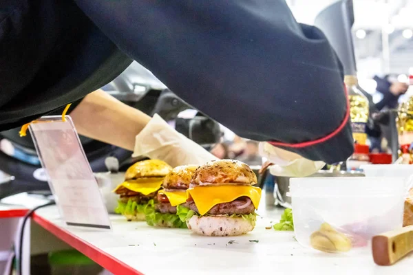 Chef is preparing beef Burger with cheese.