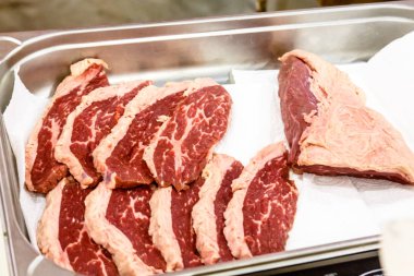 Dilimlenmiş et dilimleri içinde belgili tanımlık tepsi vardır.