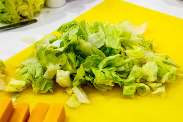 Shredded lettuce lies on the Board in the kitchen of the restaur