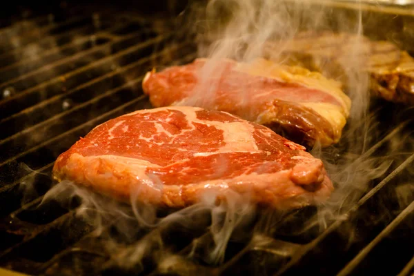 Der Koch kocht Steaks auf dem Grill. — Stockfoto