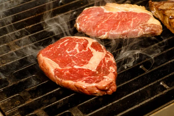 Der Koch kocht Steaks auf dem Grill. — Stockfoto