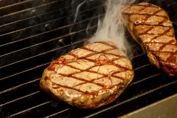 Šéfkuchař vaří steaky na grilu. — Stock fotografie