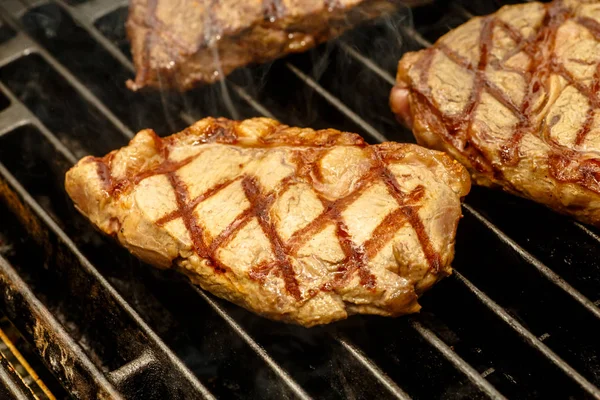 Šéfkuchař vaří steaky na grilu. — Stock fotografie